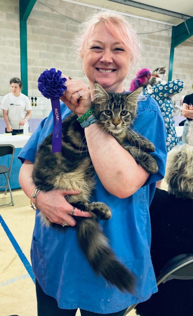 Cat with rosette and smiling woman